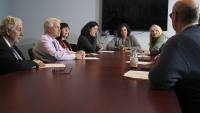 A group of researcher sitting at a table in a conference room having a discussion