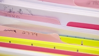 A drawer of file folders with different color tabs.