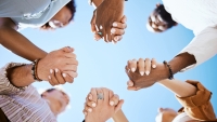 People holding hands in trust and unity for community against sky background. Hand of diverse group in solidarity for united team building collaboration and teamwork success