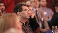 Faculty member listening to a speaker at an event