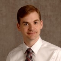 Photo of Michael Wheaton against a gray backgrounf