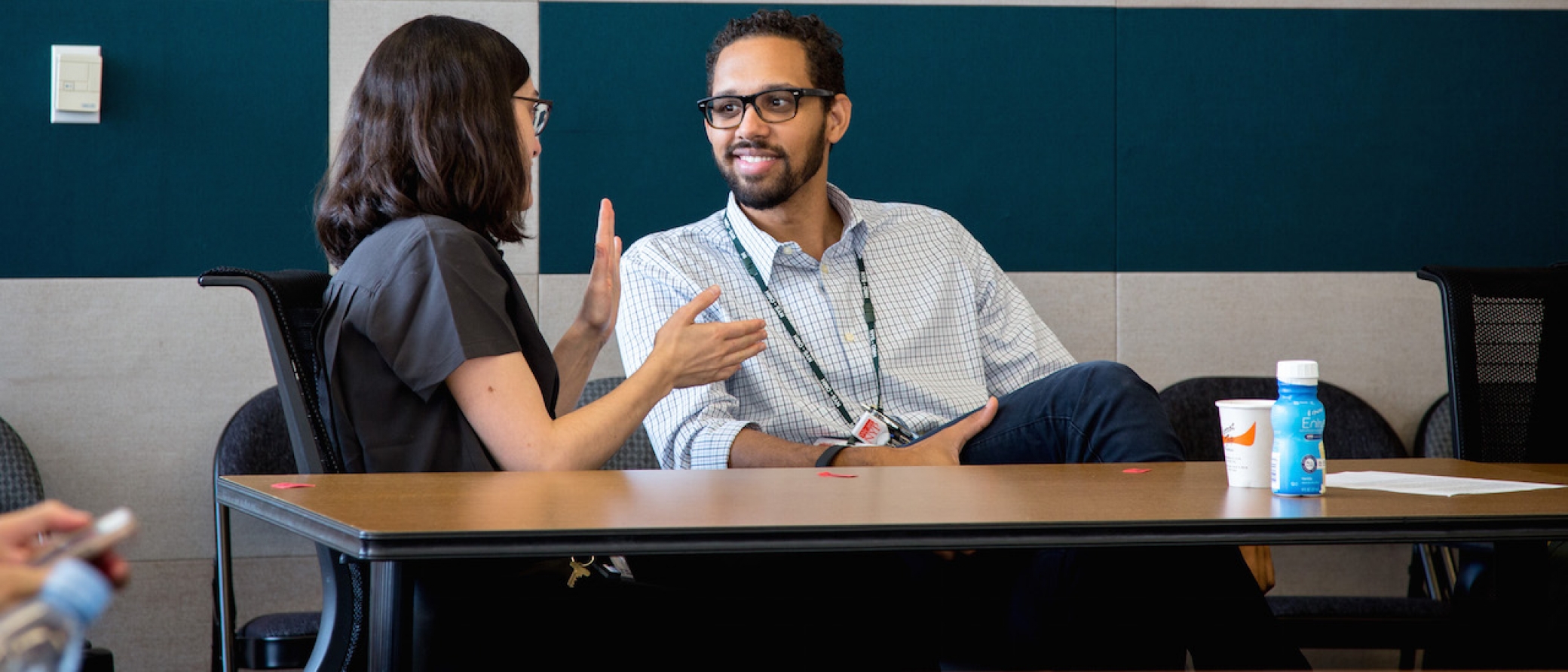 A man and woman speak to one another.